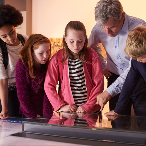 Pupils On School Field Trip To Cultural Center Looking At Map