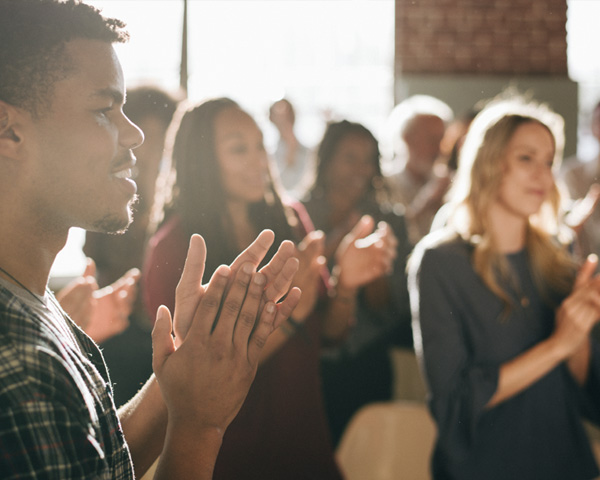 Group of diverse community members clapping at cultural center