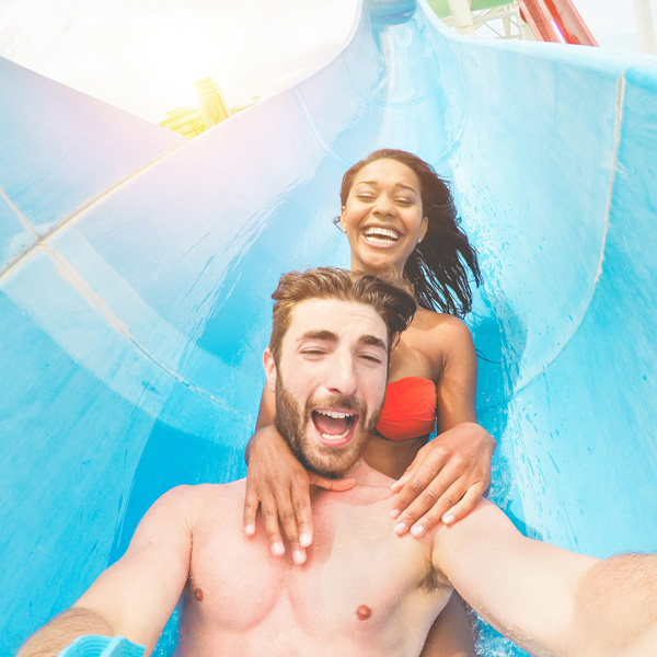 Young couple going down waterslide at a waterpark
