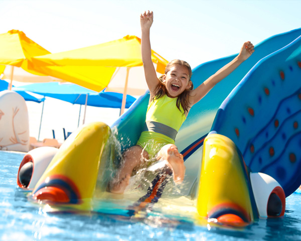 happy girl going down slide at waterpark